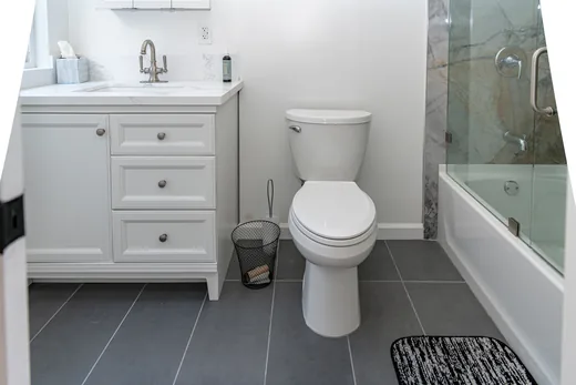 Full bathroom with a white vanity, glass shower enclosure, and tile floor