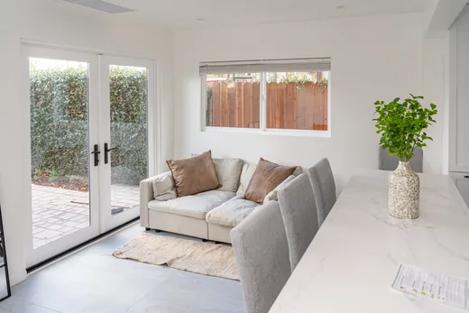 Dining table with black chairs beside sliding doors to the patio