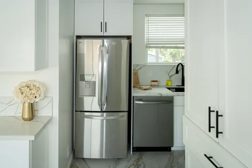 Kitchen with stainless refrigerator, dishwasher, and white shaker cabinets