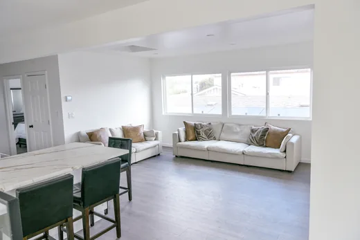Bright living room with a large sectional sofa beneath a wall of windows